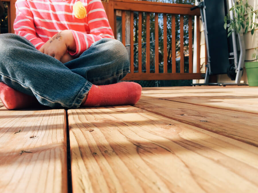 child-crossing-legs-on-porch