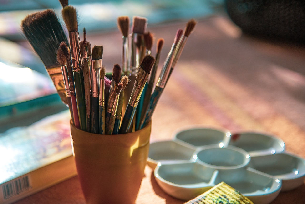 Paint brushes in a cup and a paint palette